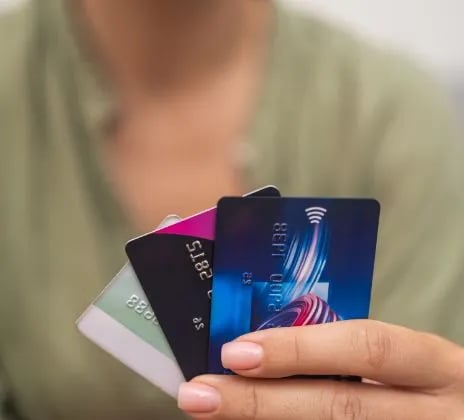 close-up-woman-hand-grasps-stack-of-credit-cards